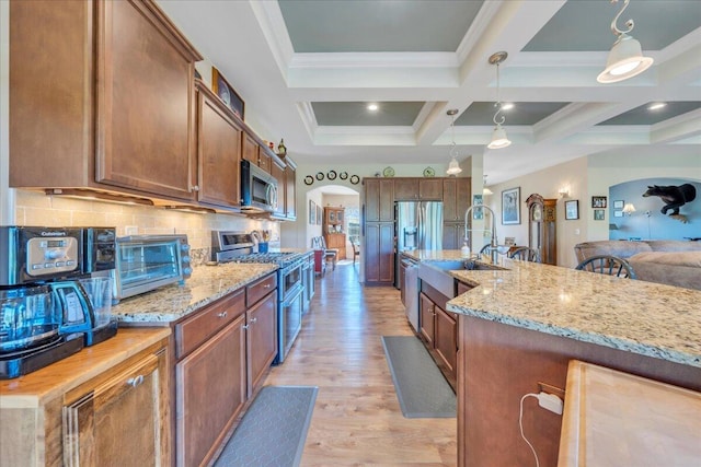 398 River Ridge Rd SE, Copper Hill, VA 24079 - kitchen featuring a sink, stainless steel appliances, light wood finished floors, pendant lighting, and decorative backsplash
