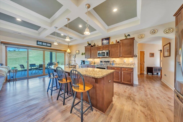 398 River Ridge Rd SE, Copper Hill, VA 24079 - kitchen with appliances with stainless steel finishes, brown cabinets, a sink, a kitchen breakfast bar, and light stone countertops