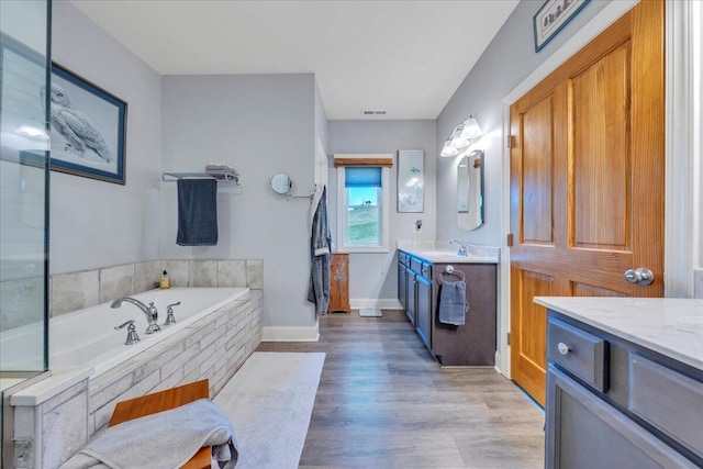 398 River Ridge Rd SE, Copper Hill, VA 24079 - bathroom featuring vanity, a garden tub, baseboards, and wood finished floors