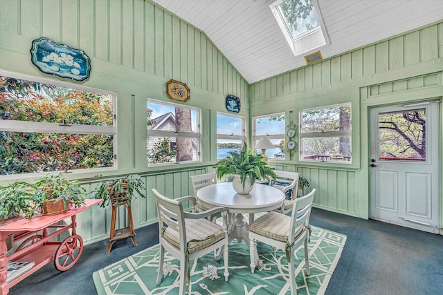 sunroom / solarium with carpet flooring, a skylight, wood walls, wooden ceiling, and high vaulted ceiling