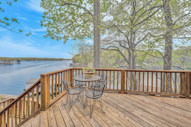 wooden deck with outdoor dining area and a water view