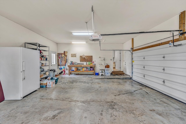 garage featuring freestanding refrigerator and a garage door opener