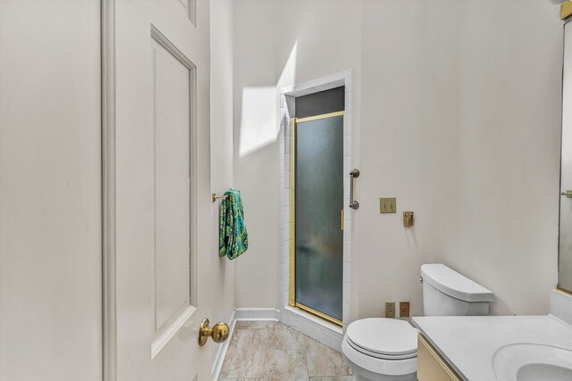 full bathroom featuring a shower stall, vanity, toilet, and baseboards