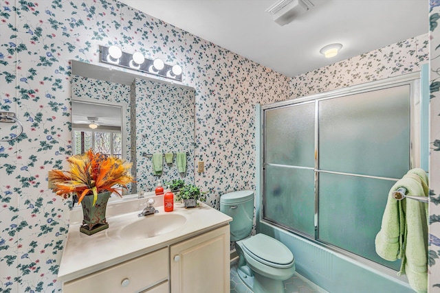 bathroom featuring wallpapered walls, vanity, enclosed tub / shower combo, and toilet
