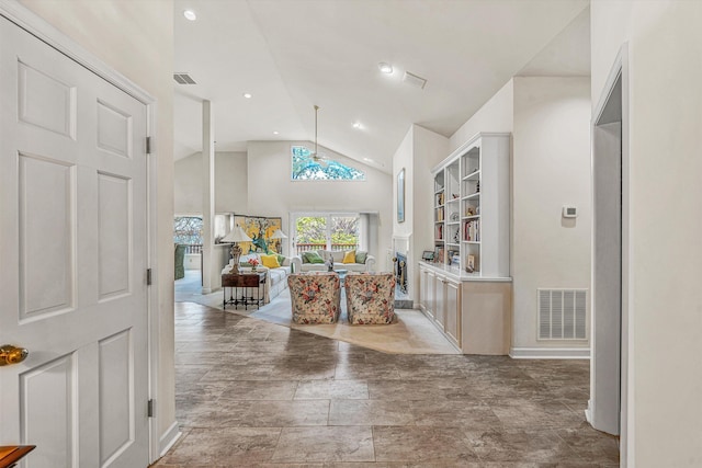 hallway with vaulted ceiling, visible vents, and baseboards