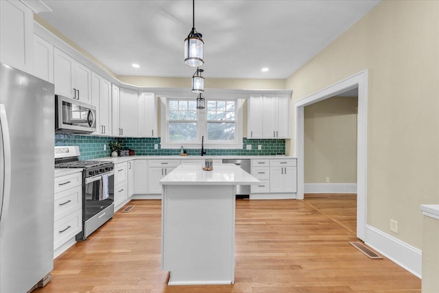 2219 Carter Rd SW, Roanoke, VA 24015 - kitchen with stainless steel appliances, tasteful backsplash, hanging light fixtures, light countertops, and white cabinets