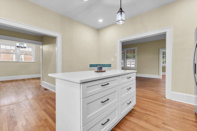 2219 Carter Rd SW, Roanoke, VA 24015 - kitchen featuring white cabinetry, hanging light fixtures, light wood-style floors, light countertops, and baseboards