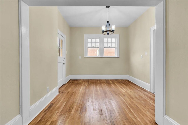 2219 Carter Rd SW, Roanoke, VA 24015 - unfurnished dining area featuring a chandelier, light wood-type flooring, and baseboards