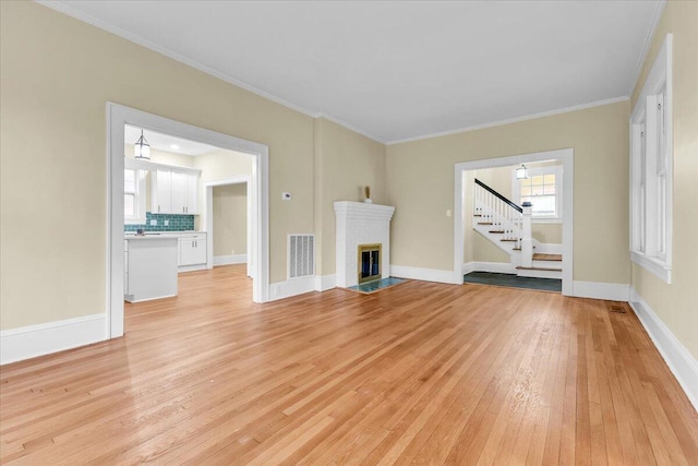 2219 Carter Rd SW, Roanoke, VA 24015 - unfurnished living room with light wood finished floors, stairway, a fireplace, baseboards, and crown molding