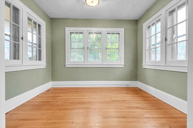 2219 Carter Rd SW, Roanoke, VA 24015 - spare room with light wood-style flooring, baseboards, and a textured ceiling