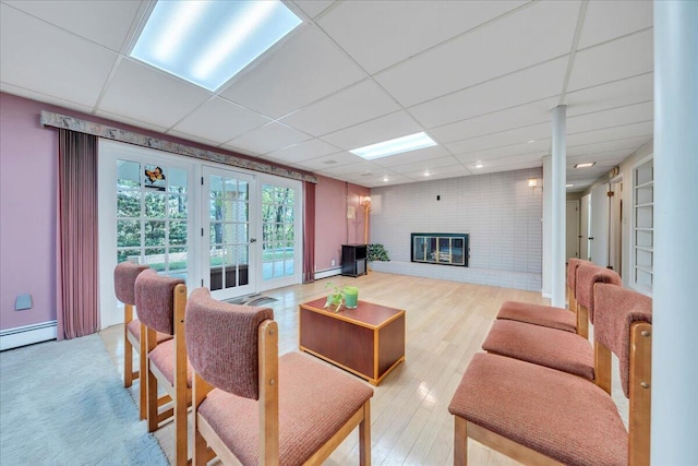 5241 N Spring Dr, Roanoke, VA 24019 - living area featuring french doors, a baseboard radiator, a fireplace, light wood-style flooring, and a paneled ceiling