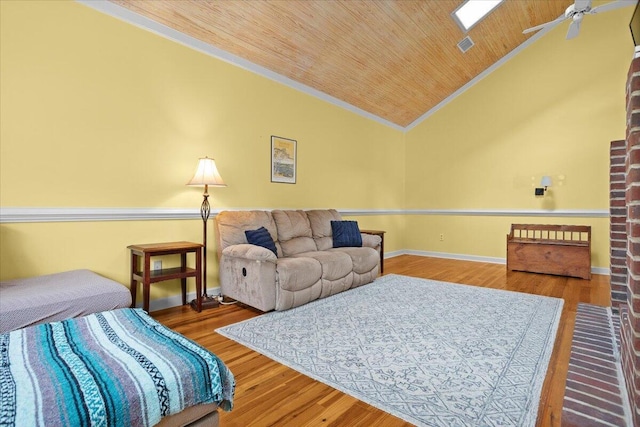 living area featuring vaulted ceiling, crown molding, ceiling fan, wood ceiling, and wood finished floors