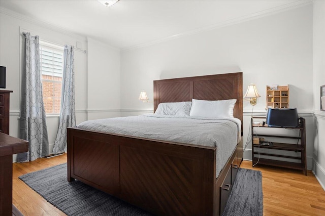 bedroom with ornamental molding and light wood-type flooring