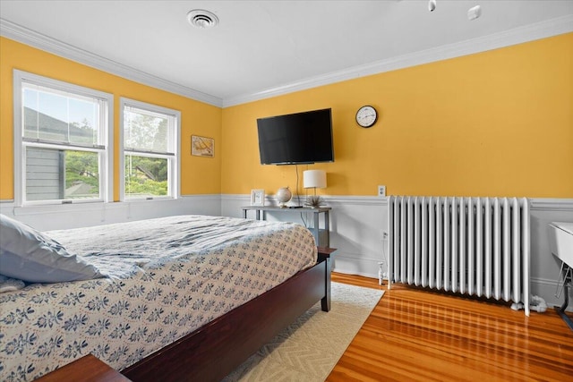 2509 Rosalind Ave SW, Roanoke, VA 24014 - bedroom with radiator heating unit, ornamental molding, a wainscoted wall, and wood finished floors