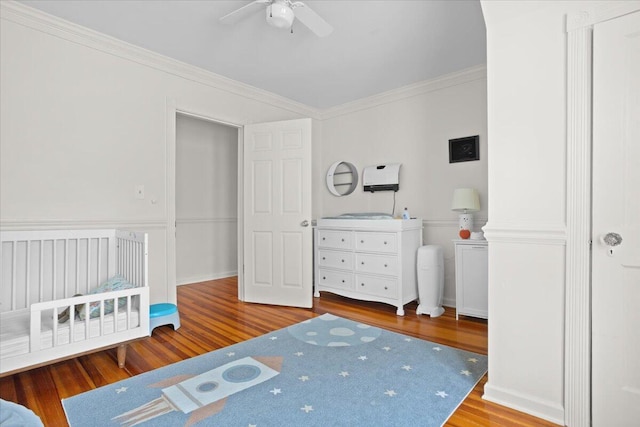 bedroom featuring wood finished floors, crown molding, and a ceiling fan