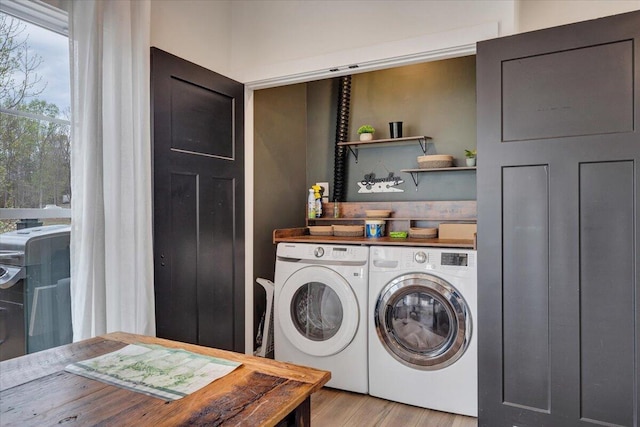 laundry area featuring light wood-style flooring, laundry area, and separate washer and dryer