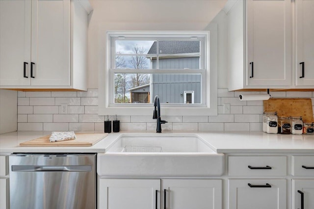 kitchen with tasteful backsplash, white cabinetry, dishwasher, light countertops, and a sink