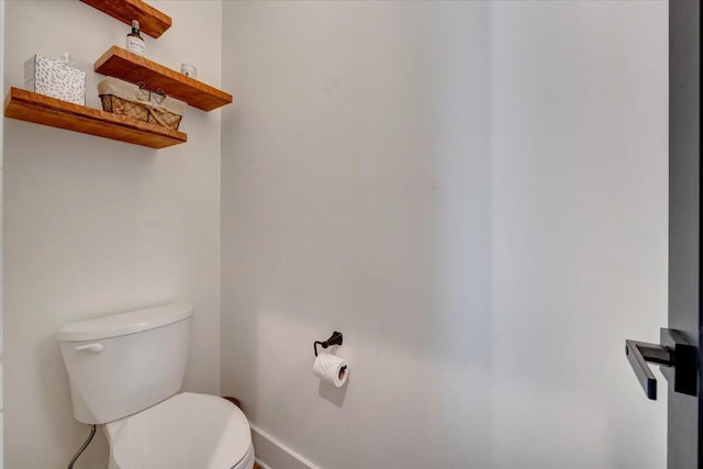 bathroom with toilet and baseboards