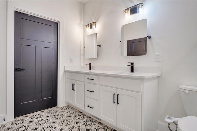 bathroom featuring toilet, tile patterned floors, and a sink