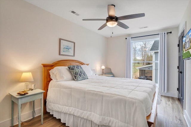 bedroom with visible vents, a ceiling fan, and wood finished floors