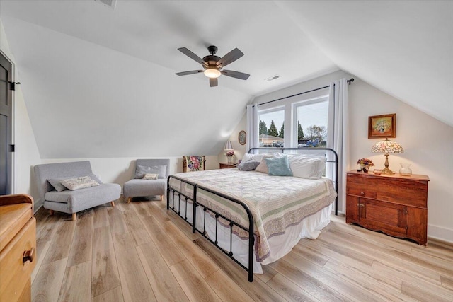 bedroom featuring ceiling fan, visible vents, light wood-type flooring, and lofted ceiling