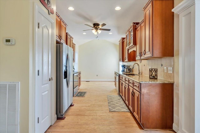 kitchen with a sink, stainless steel fridge, visible vents, light wood-style floors, and ceiling fan