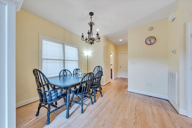 dining space with light wood-type flooring, visible vents, baseboards, and a notable chandelier
