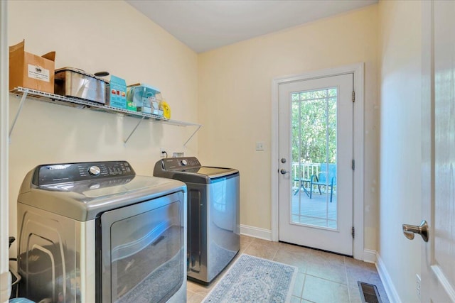 clothes washing area with washing machine and clothes dryer, light tile patterned flooring, laundry area, baseboards, and visible vents