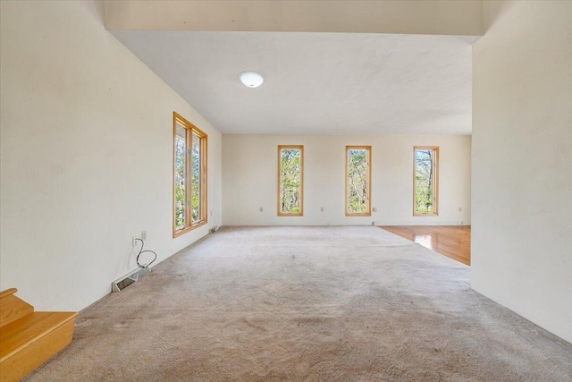 spare room with carpet flooring, visible vents, and stairs