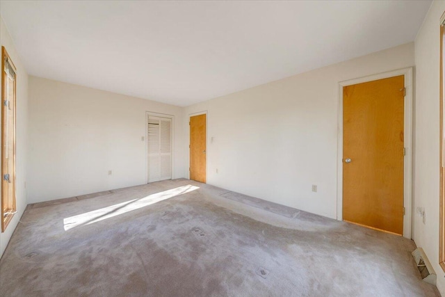 unfurnished bedroom featuring a closet, carpet flooring, and visible vents