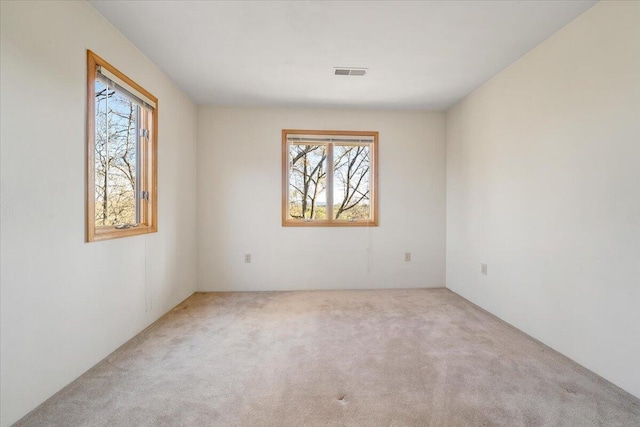 spare room with visible vents and carpet flooring