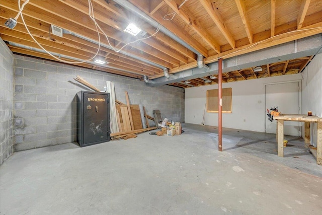 unfinished basement featuring concrete block wall