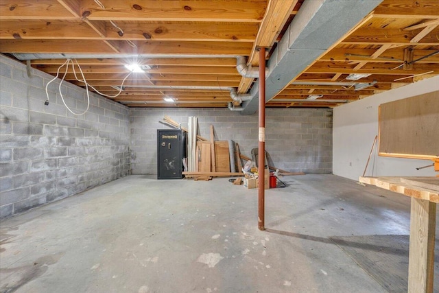 unfinished basement featuring concrete block wall