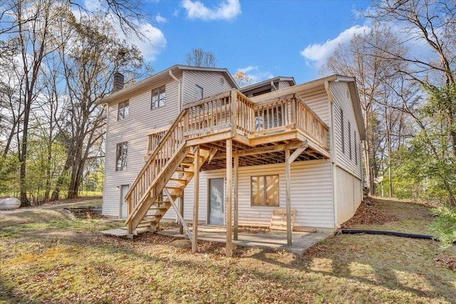 back of property with a chimney, a deck, and stairs