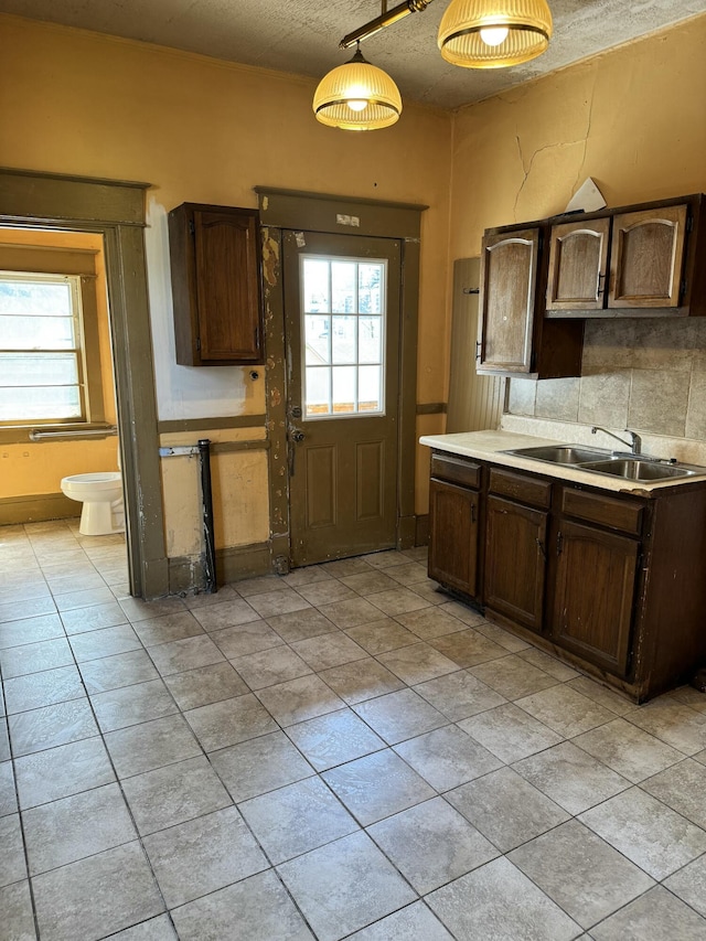 kitchen featuring a sink, light tile patterned floors, a wealth of natural light, and light countertops