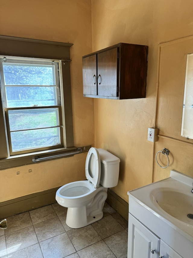 bathroom featuring toilet, tile patterned floors, vanity, and baseboards