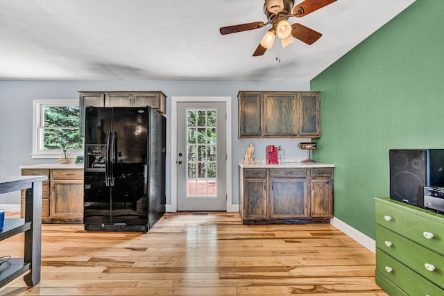 kitchen with ceiling fan, light wood-style flooring, black fridge, light countertops, and lofted ceiling