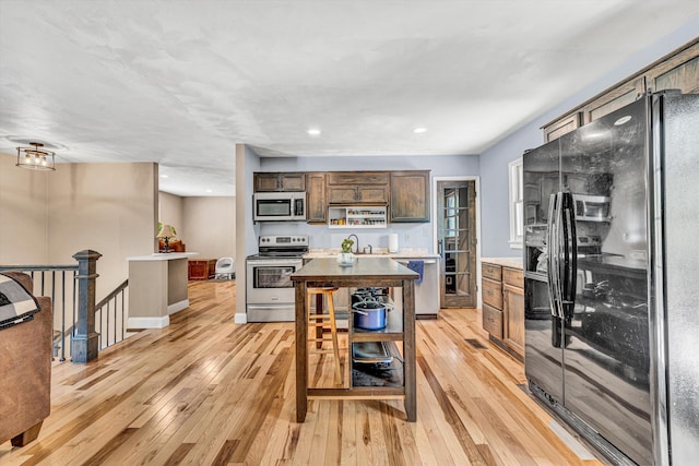 kitchen with light wood finished floors, light countertops, recessed lighting, and stainless steel appliances