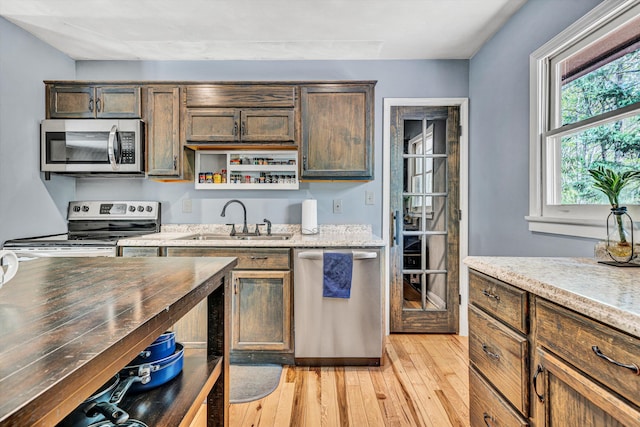 kitchen featuring light wood finished floors, a sink, and appliances with stainless steel finishes