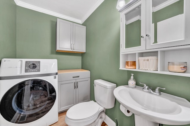 half bath with crown molding, toilet, washer / dryer, a sink, and wood finished floors