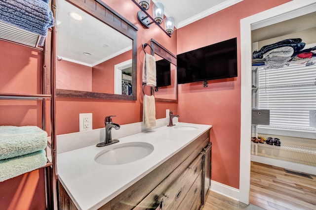 full bathroom with visible vents, a sink, ornamental molding, double vanity, and wood finished floors