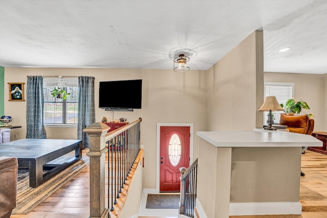 entrance foyer featuring light wood finished floors, baseboards, and a wealth of natural light