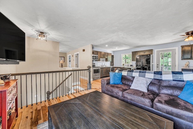 living room featuring light wood-style flooring and a ceiling fan
