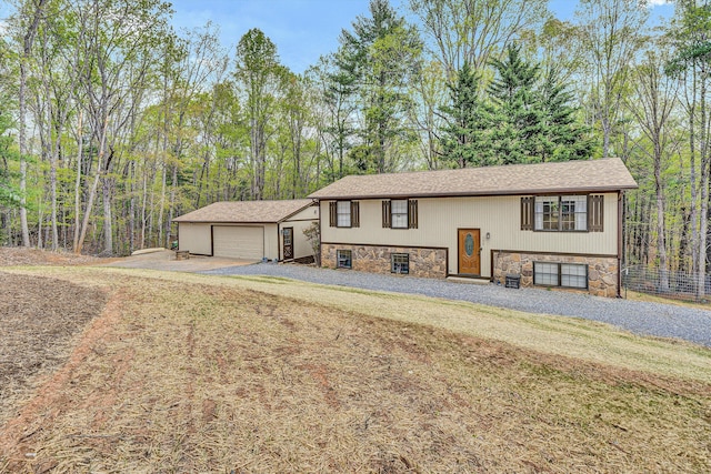 view of front facade featuring stone siding, an outbuilding, and a detached garage