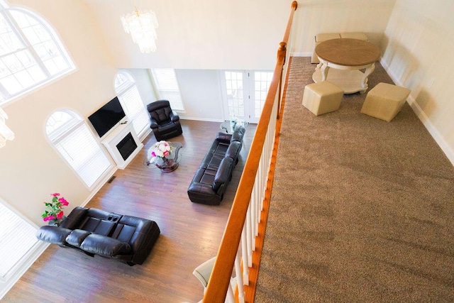 living room featuring plenty of natural light, wood finished floors, and an inviting chandelier