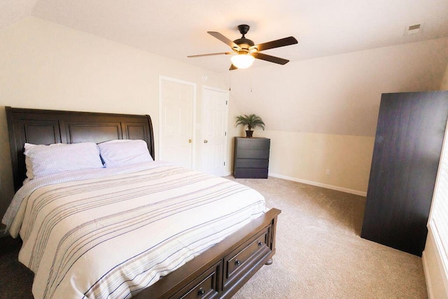 bedroom with vaulted ceiling, ceiling fan, light colored carpet, baseboards, and visible vents