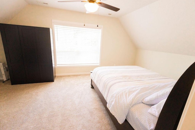bedroom featuring lofted ceiling, a ceiling fan, visible vents, and carpet floors