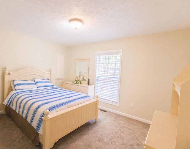 bedroom featuring baseboards, visible vents, a textured ceiling, and light colored carpet