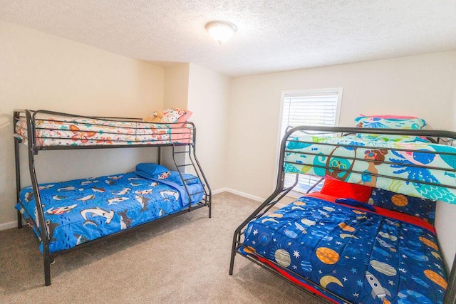 carpeted bedroom with baseboards and a textured ceiling