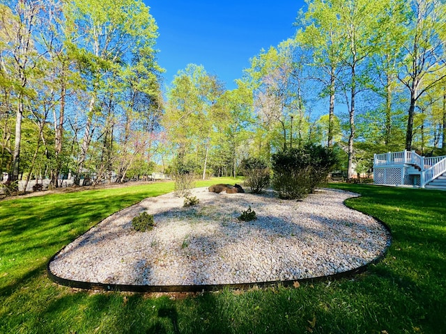 view of community featuring a deck, stairway, and a lawn